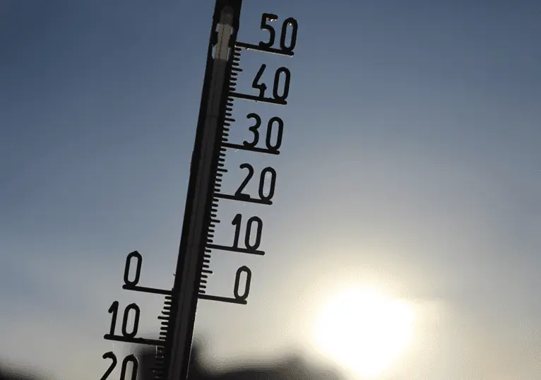 Thermometer against a sunny sky, showing the role of temperature in kefir fermentation